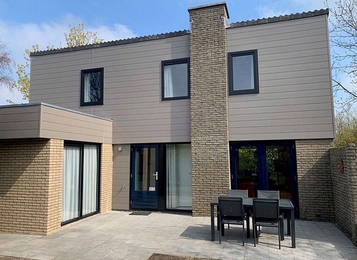 Vakantiehuis C 067 in De Cocksdorp, Texel biedt een charmante buitenkant omgeven door groen, ideaal voor een ontspannen verblijf op de Waddeneilanden.