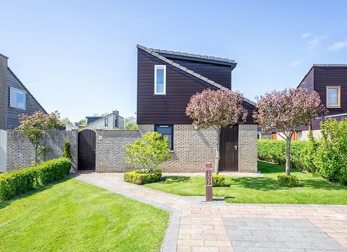 Vacation home A 309 in De Cocksdorp, Texel, offers a charming exterior with green garden and modern architecture on the Wadden Islands.