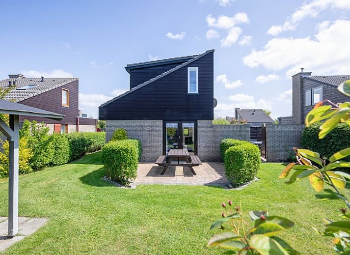 Vacation home A 309 in De Cocksdorp, Texel, offers a charming exterior with green garden and modern architecture on the Wadden Islands.