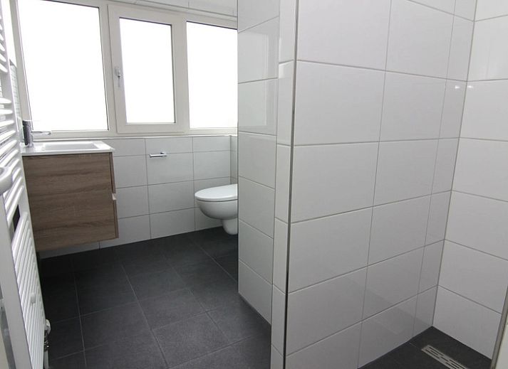 Ingang van Vakantiehuis E 632 in De Cocksdorp, Texel, met zonnig terras en omringd door groene natuur op de Waddeneilanden.