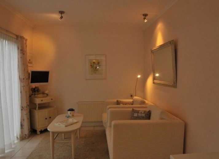 Gemuetliche Terrasse am Ferienhaus Dunaa in De Koog, Texel, umgeben von Blumen und Sitzgelegenheiten.