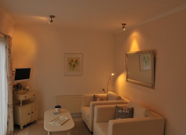 Ruhiger Aussenbereich des Ferienhauses Dunaa in De Koog, Texel, mit Holzschuppen und bluehenden Pflanzen.