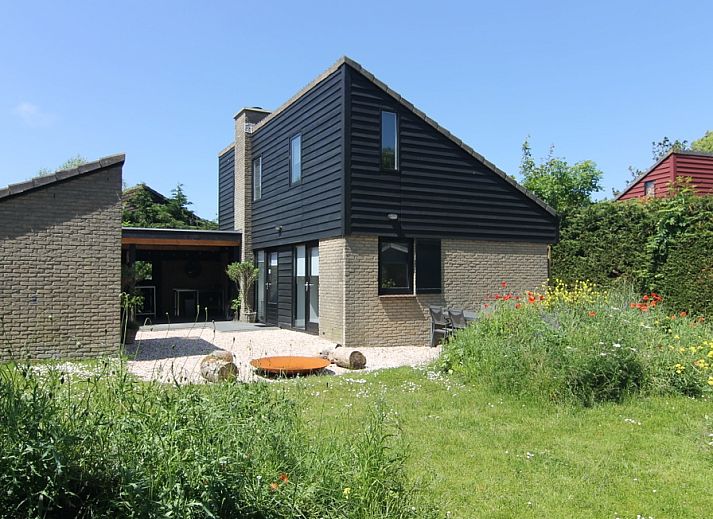 Vakantiehuis C 081 in De Cocksdorp, Texel, biedt een charmant terras met uitzicht op een weelderige tuin en moderne architectuur.