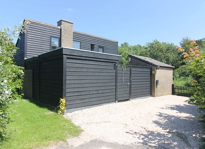 Vakantiehuis C 081 in De Cocksdorp, Texel, biedt een charmant terras met uitzicht op een weelderige tuin en moderne architectuur.