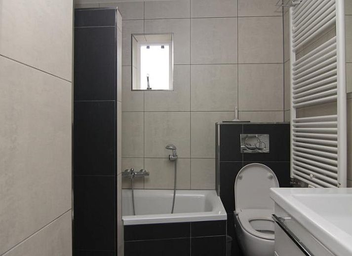 Das Ferienhaus D640 in De Cocksdorp, Texel, bietet einen charmanten Aussenbereich mit einem grossen Garten und einem Holzzaun, ideal fuer einen entspannten Aufenthalt.