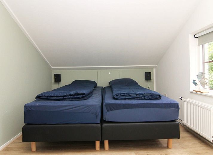 Das Ferienhaus D640 in De Cocksdorp, Texel, bietet einen charmanten Aussenbereich mit einem grossen Garten und einem Holzzaun, ideal fuer einen entspannten Aufenthalt.