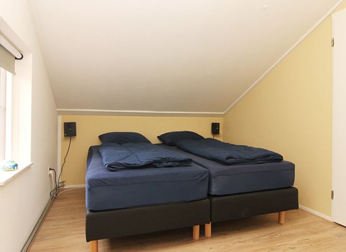 Das Ferienhaus D640 in De Cocksdorp, Texel, bietet einen charmanten Aussenbereich mit einem grossen Garten und einem Holzzaun, ideal fuer einen entspannten Aufenthalt.