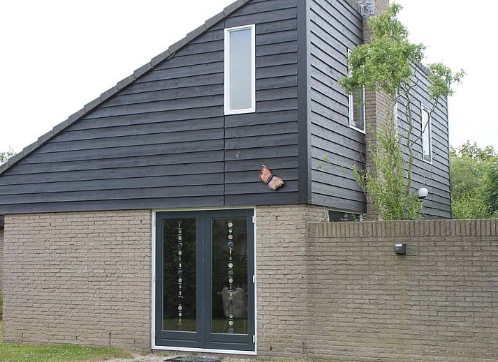 Vakantiehuis A 267 in De Cocksdorp, Texel, biedt een moderne buitenkant met houten gevels, ideaal voor een ontspannen verblijf op de Waddeneilanden.