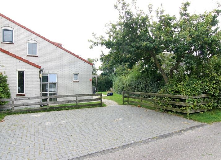 Vakantiehuis D 533 in De Cocksdorp, Texel, biedt een rustige omgeving met groene natuur en een uitnodigend terras voor ontspanning.