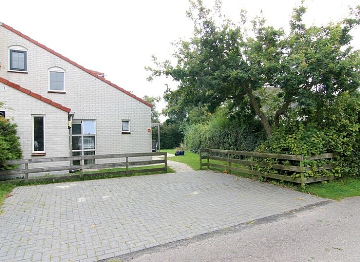 Vakantiehuis D 533 in De Cocksdorp, Texel, biedt een rustige omgeving met groene natuur en een uitnodigend terras voor ontspanning.
