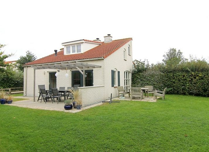Vakantiehuis D 533 in De Cocksdorp, Texel, biedt een rustige omgeving met groene natuur en een uitnodigend terras voor ontspanning.