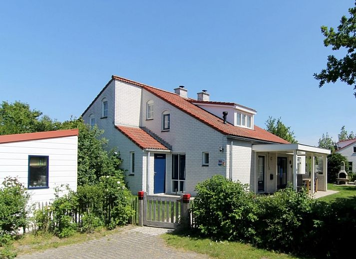 Das Ferienhaus D 707 in De Cocksdorp, Texel, bietet eine charmante Unterkunft mit einer sonnigen Veranda und gruener Umgebung auf den Watteninseln.