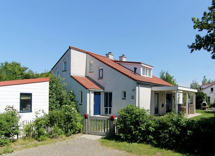 Das Ferienhaus D 707 in De Cocksdorp, Texel, bietet eine charmante Unterkunft mit einer sonnigen Veranda und gruener Umgebung auf den Watteninseln.