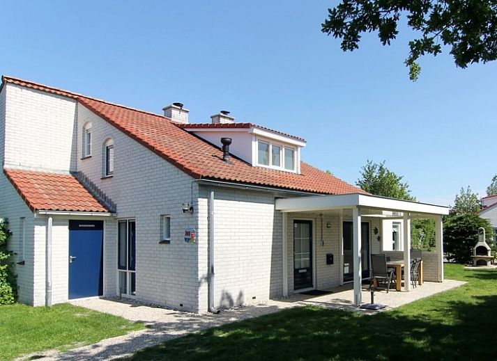 Das Ferienhaus D 707 in De Cocksdorp, Texel, bietet eine charmante Unterkunft mit einer sonnigen Veranda und gruener Umgebung auf den Watteninseln.