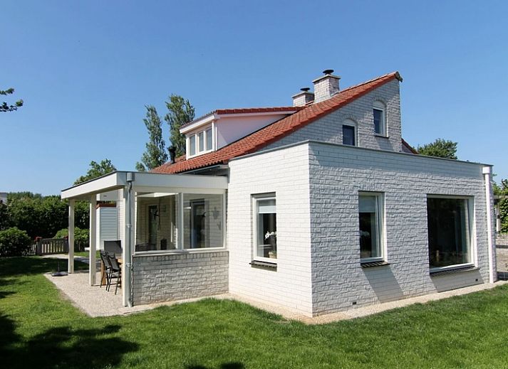 Das Ferienhaus D 707 in De Cocksdorp, Texel, bietet eine charmante Unterkunft mit einer sonnigen Veranda und gruener Umgebung auf den Watteninseln.