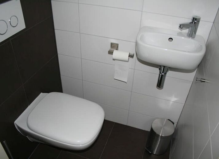 Vakantiehuis D 696 in De Cocksdorp, Texel met zonnige veranda en groene omgeving, ideaal voor een ontspannen verblijf op de Waddeneilanden.