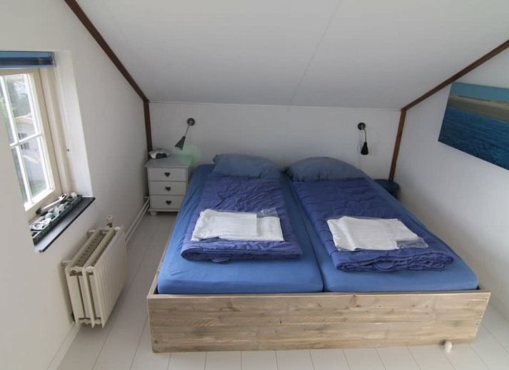 Vakantiehuis D 696 in De Cocksdorp, Texel met zonnige veranda en groene omgeving, ideaal voor een ontspannen verblijf op de Waddeneilanden.