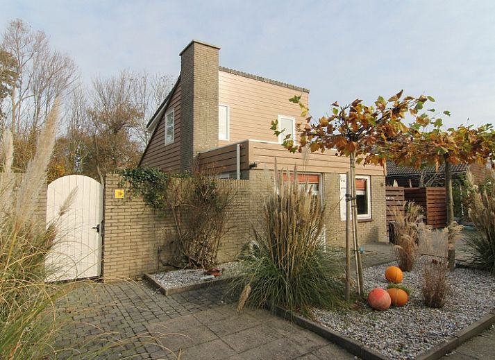 Vakantiehuis B 015 in De Cocksdorp, Texel biedt een charmante buitenruimte met herfstige tuin en moderne architectuur op de Waddeneilanden.
