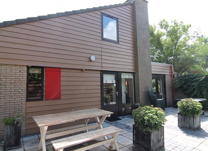 Vakantiehuis B 015 in De Cocksdorp, Texel biedt een charmante buitenruimte met herfstige tuin en moderne architectuur op de Waddeneilanden.