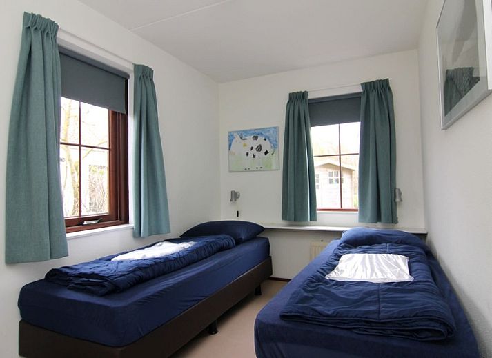 Vakantiehuis E 655 in De Cocksdorp, Texel biedt een charmante buitenaanzicht met groene omgeving en rustige sfeer op de Waddeneilanden.