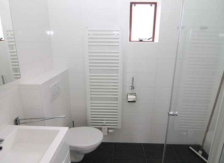 Vakantiehuis E 655 in De Cocksdorp, Texel biedt een charmante buitenaanzicht met groene omgeving en rustige sfeer op de Waddeneilanden.