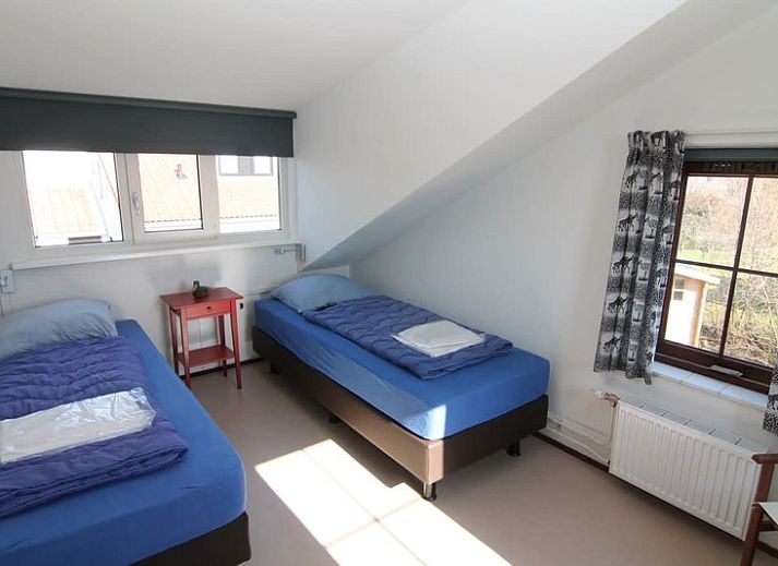 Vakantiehuis E 655 in De Cocksdorp, Texel biedt een charmante buitenaanzicht met groene omgeving en rustige sfeer op de Waddeneilanden.