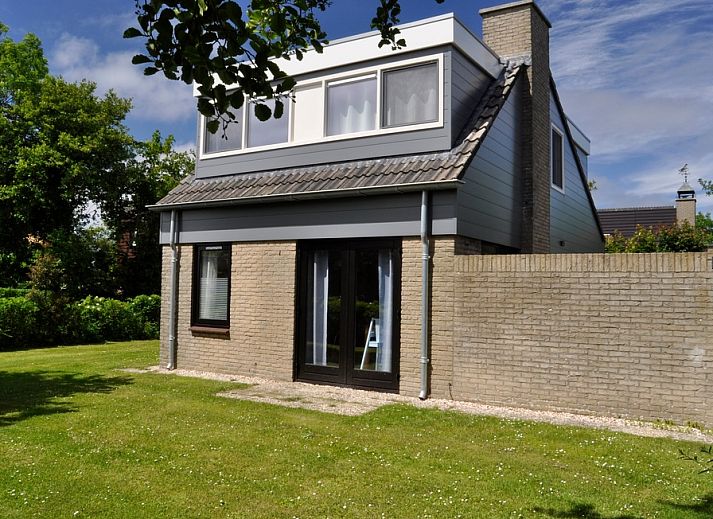 Das Ferienhaus B 043 in De Cocksdorp, Texel, bietet einen ruhigen Garten und eine moderne Architektur fuer einen erholsamen Aufenthalt auf den Watteninseln.