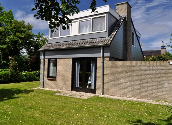 Das Ferienhaus B 043 in De Cocksdorp, Texel, bietet einen ruhigen Garten und eine moderne Architektur fuer einen erholsamen Aufenthalt auf den Watteninseln.
