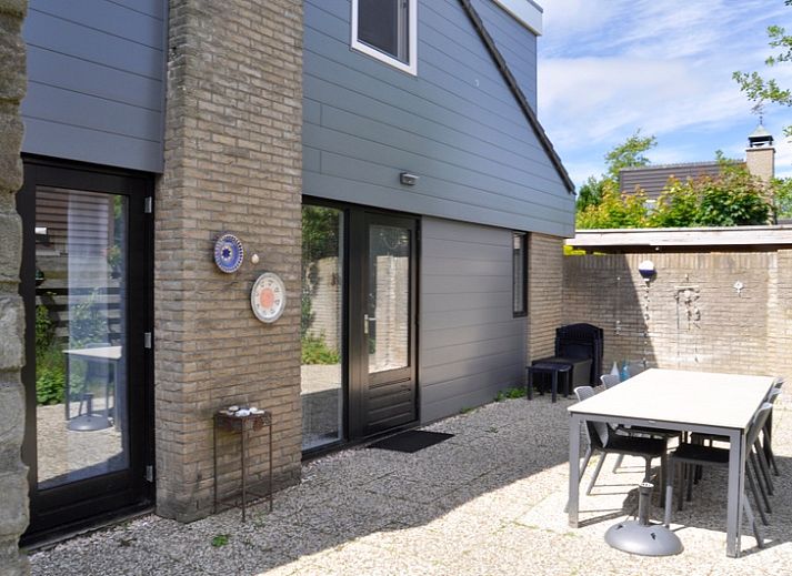 Das Ferienhaus B 043 in De Cocksdorp, Texel, bietet einen ruhigen Garten und eine moderne Architektur fuer einen erholsamen Aufenthalt auf den Watteninseln.