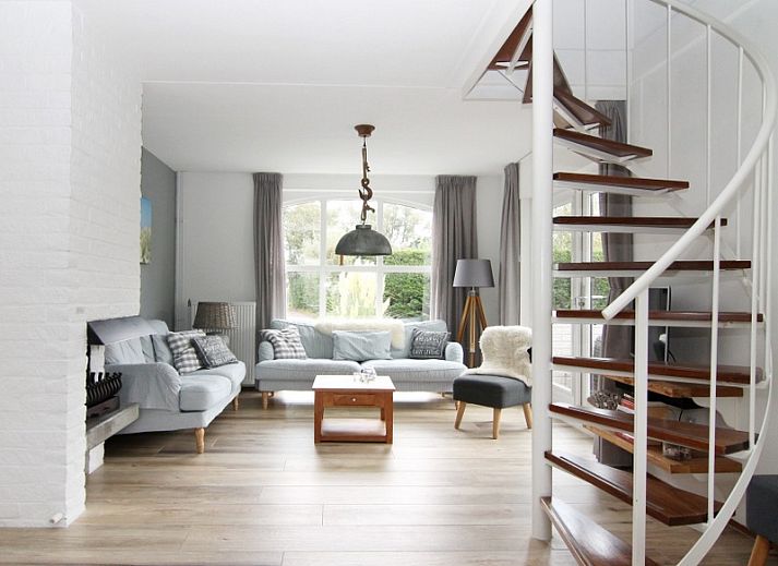 Vakantiehuis E 545 in De Cocksdorp, Texel, met charmante witte gevel en groene omgeving, ideaal voor een ontspannen verblijf op de Waddeneilanden.