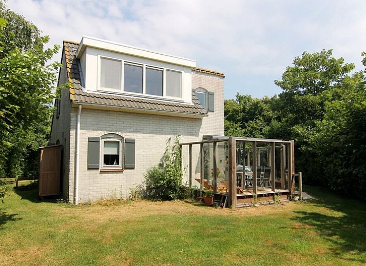 Vakantiehuis F 654 in De Cocksdorp, Texel, Waddeneilanden, omgeven door groene natuur en een zonnig terras voor een ontspannen verblijf.