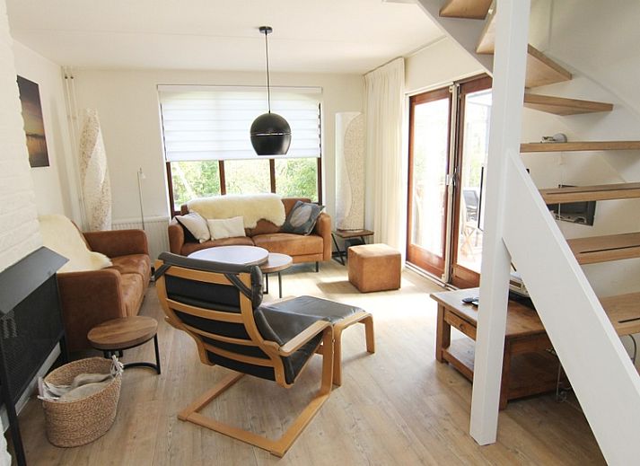 Vakantiehuis F 654 in De Cocksdorp, Texel, omgeven door groene tuin en blauwe lucht, ideaal voor een ontspannen verblijf op de Waddeneilanden.