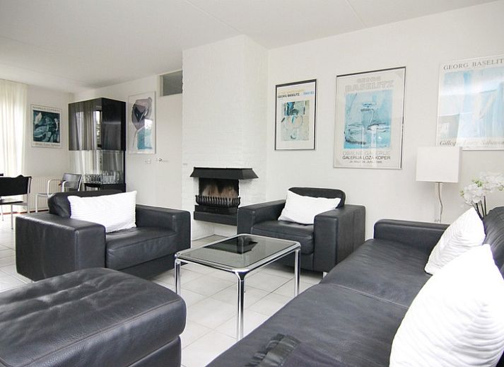 Vakantiehuis E 638 in De Cocksdorp, Texel, omgeven door bloeiende rozenstruiken en een zonnige tuin, ideaal voor een ontspannen verblijf.