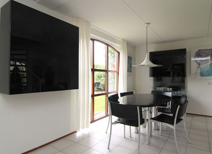 Vakantiehuis E 638 in De Cocksdorp, Texel, omgeven door bloeiende rozenstruiken en een zonnige tuin, ideaal voor een ontspannen verblijf.