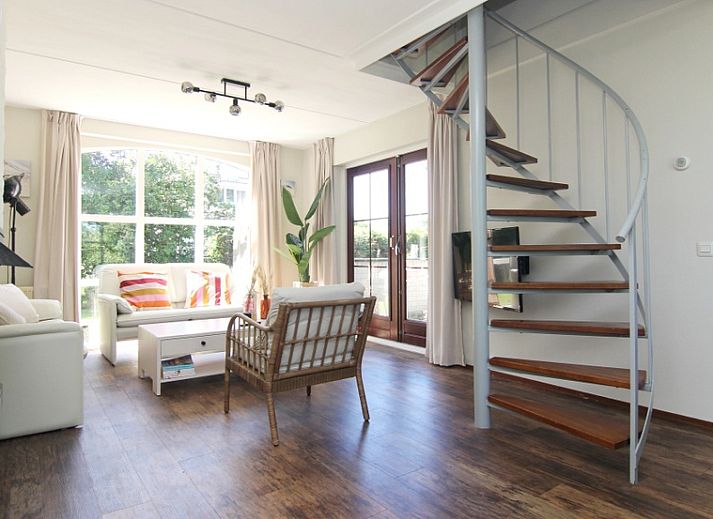 Das Ferienhaus F 567 in De Cocksdorp, Texel, bietet einen schoenen Aussenbereich mit einer geschlossenen Terrasse, ideal fuer einen entspannten Aufenthalt auf den Watteninseln.