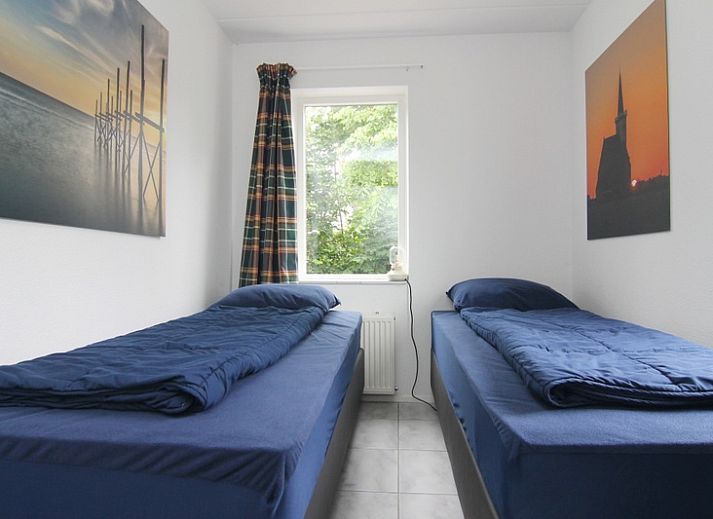 Vakantiehuis F 647 in De Cocksdorp, Texel, biedt een charmante buitenkant met een groene tuin, ideaal voor ontspanning op de Waddeneilanden.