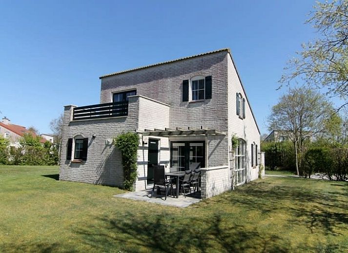 Vakantiehuis F 604 in De Cocksdorp, Texel, biedt een serene buitenomgeving met een betegeld pad en groene natuur rondom.