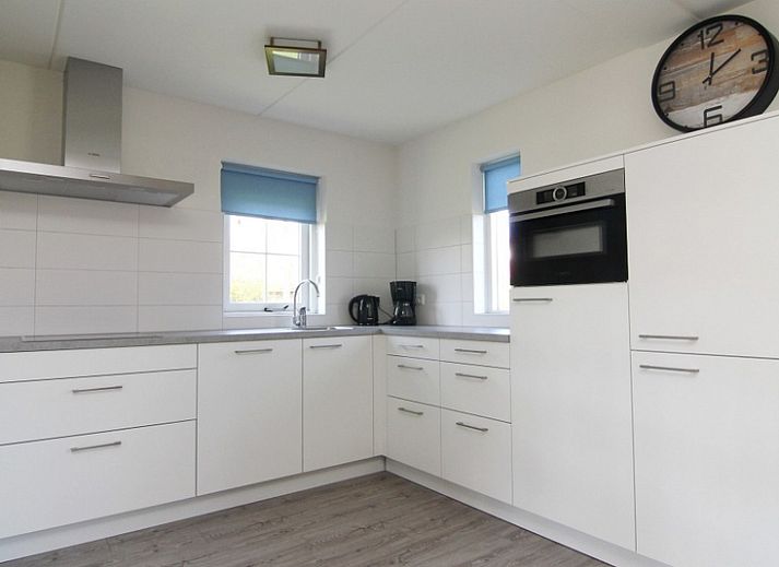 Vakantiehuis F 604 in De Cocksdorp, Texel biedt een serene buitenomgeving met een uitnodigend terras omringd door groen.