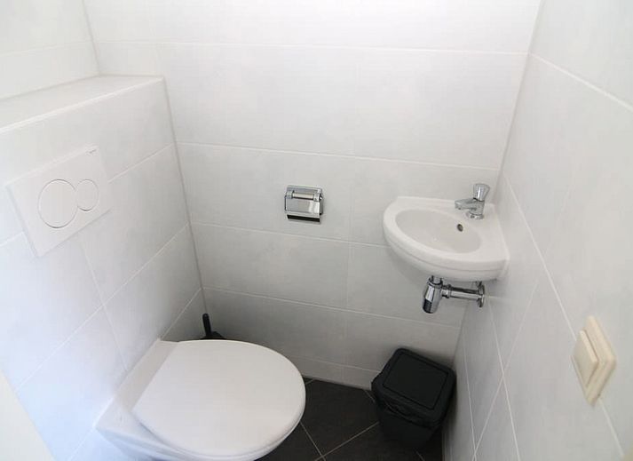 Vakantiehuis F 604 in De Cocksdorp, Texel biedt een serene buitenomgeving met een uitnodigend terras omringd door groen.