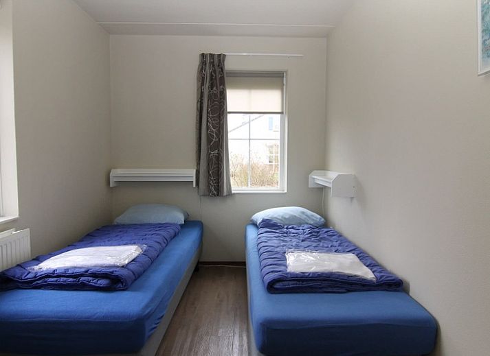 Vakantiehuis F 604 in De Cocksdorp, Texel biedt een serene buitenomgeving met een uitnodigend terras omringd door groen.