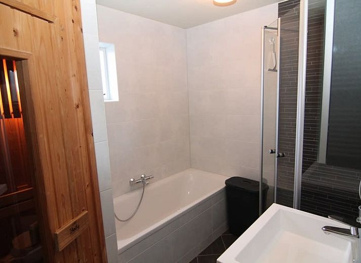 Vakantiehuis F 604 in De Cocksdorp, Texel biedt een serene buitenomgeving met een uitnodigend terras omringd door groen.