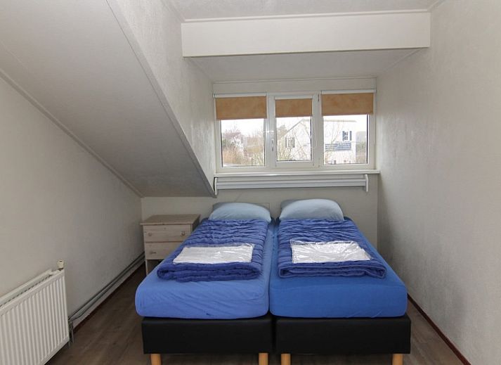 Vakantiehuis F 604 in De Cocksdorp, Texel biedt een serene buitenomgeving met een uitnodigend terras omringd door groen.