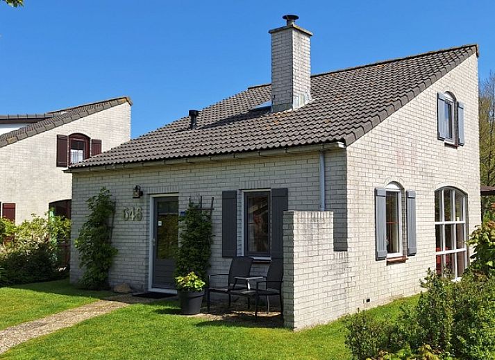 Vakantiehuis E 646 in De Cocksdorp, Texel biedt een charmante buitenruimte met groene tuin en comfortabele zitplek, ideaal voor ontspanning.