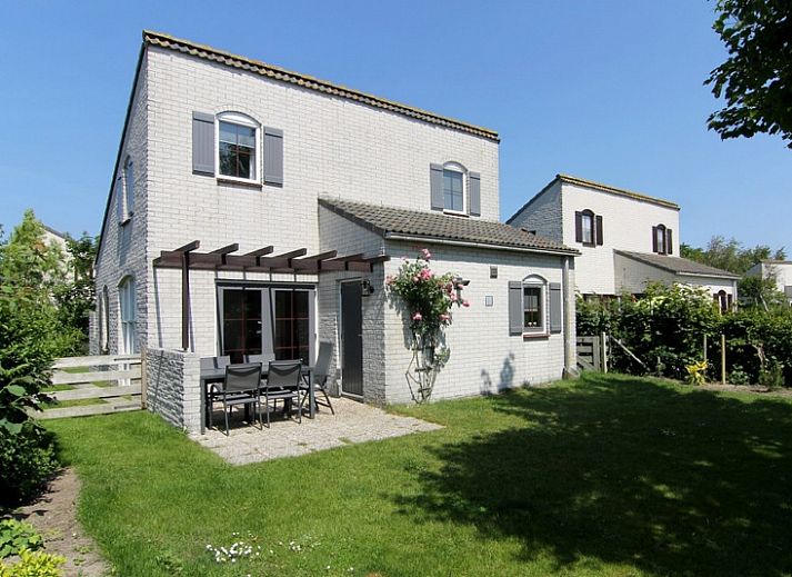 Vakantiehuis E 646 in De Cocksdorp, Texel biedt een charmante buitenruimte met groene tuin en comfortabele zitplek, ideaal voor ontspanning.