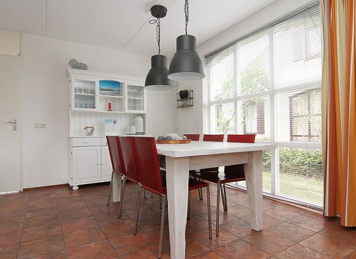 Vakantiehuis E 646 in De Cocksdorp, Texel biedt een charmante buitenruimte met groene tuin en comfortabele zitplek, ideaal voor ontspanning.