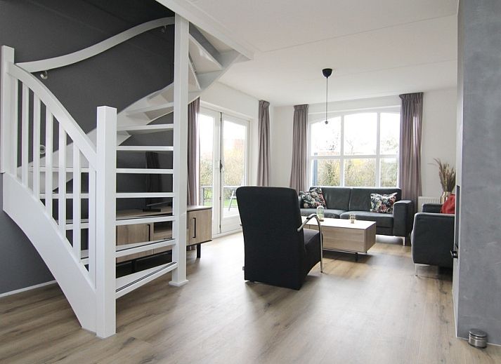 Gezellige woonkamer in Vakantiehuis E 507, De Cocksdorp, Texel, met moderne inrichting en uitzicht op de groene omgeving van de Waddeneilanden.