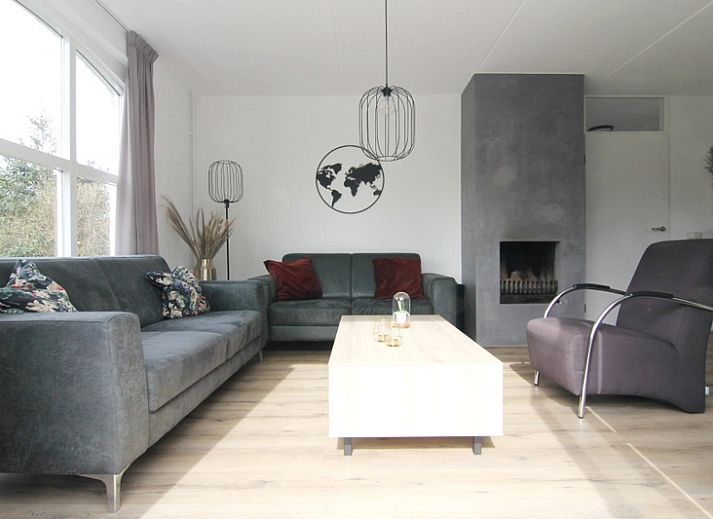 Gezellige woonkamer in Vakantiehuis E 507, De Cocksdorp, Texel, met moderne inrichting en uitzicht op de groene omgeving van de Waddeneilanden.