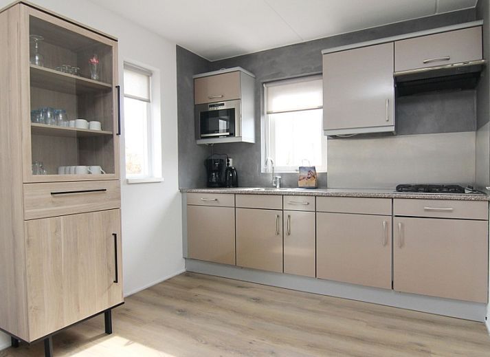 Gezellige woonkamer in Vakantiehuis E 507, De Cocksdorp, Texel, met moderne inrichting en uitzicht op de groene omgeving van de Waddeneilanden.