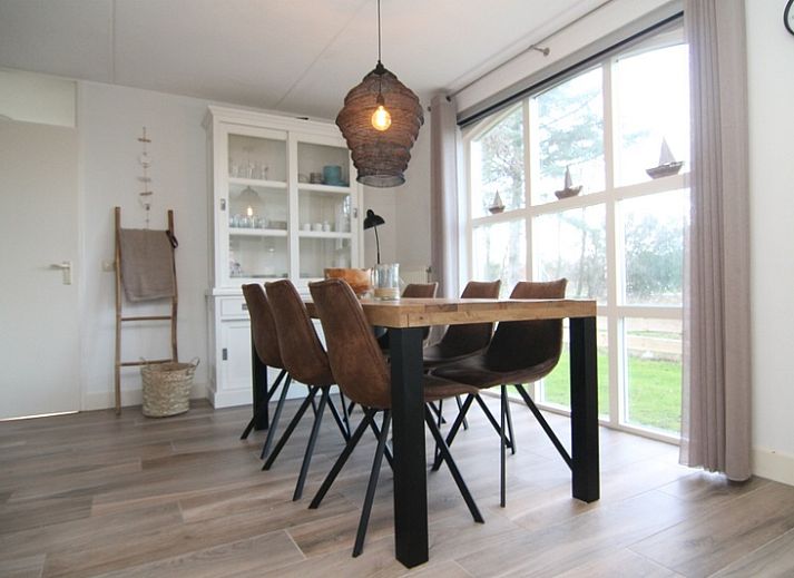 Das Ferienhaus F 778 in De Cocksdorp, Texel, bietet einen ruhigen Aussenbereich mit gruener Umgebung und einer grossen Terrasse zum Entspannen auf den Watteninseln.