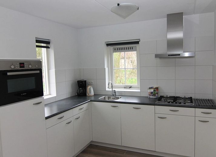 Das Ferienhaus F 778 in De Cocksdorp, Texel, bietet einen ruhigen Aussenbereich mit gruener Umgebung und einer grossen Terrasse zum Entspannen auf den Watteninseln.